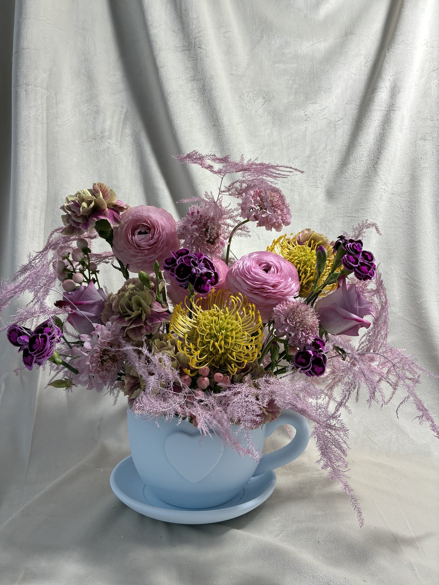 Pastel Reverie – Aranjament floral în ceașcă cu ranunculus și accente exotice