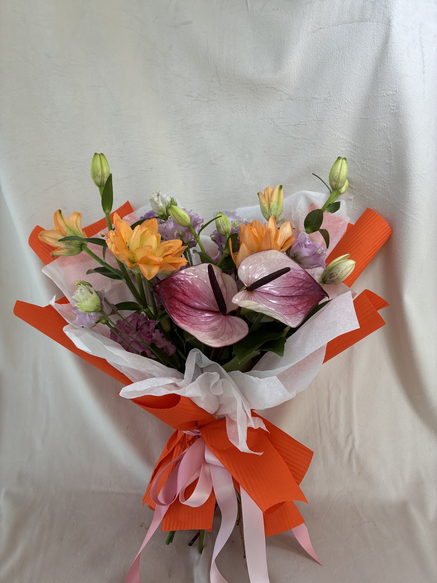 Coral Whisper – Buchet Elegant cu Anthurium Roz, Crini Portocalii și Eustoma Delicată