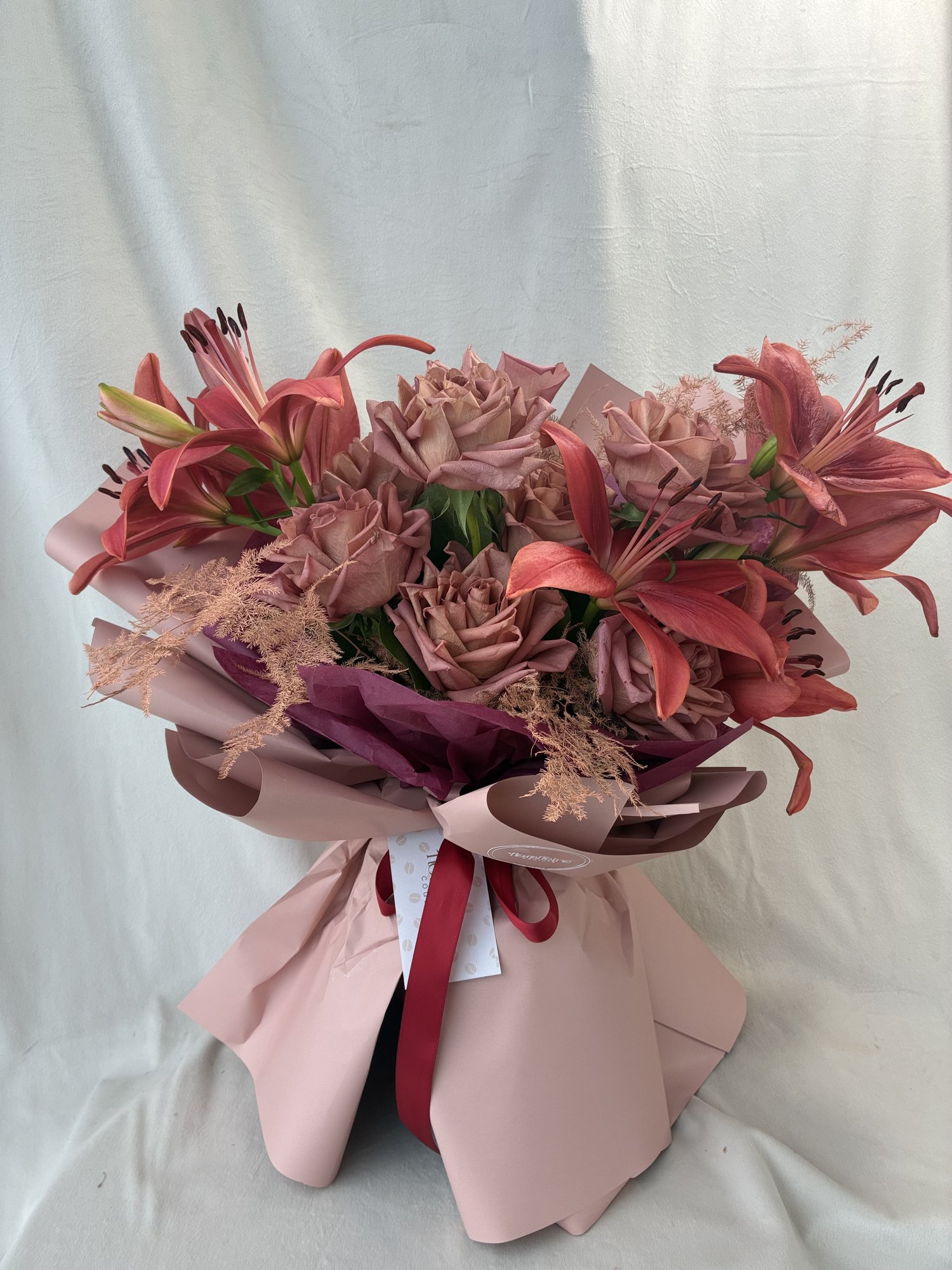 Velvet Ember – Buchet premium cu trandafiri Mocha, crini somon și asparagus decorativ - Imagine 3