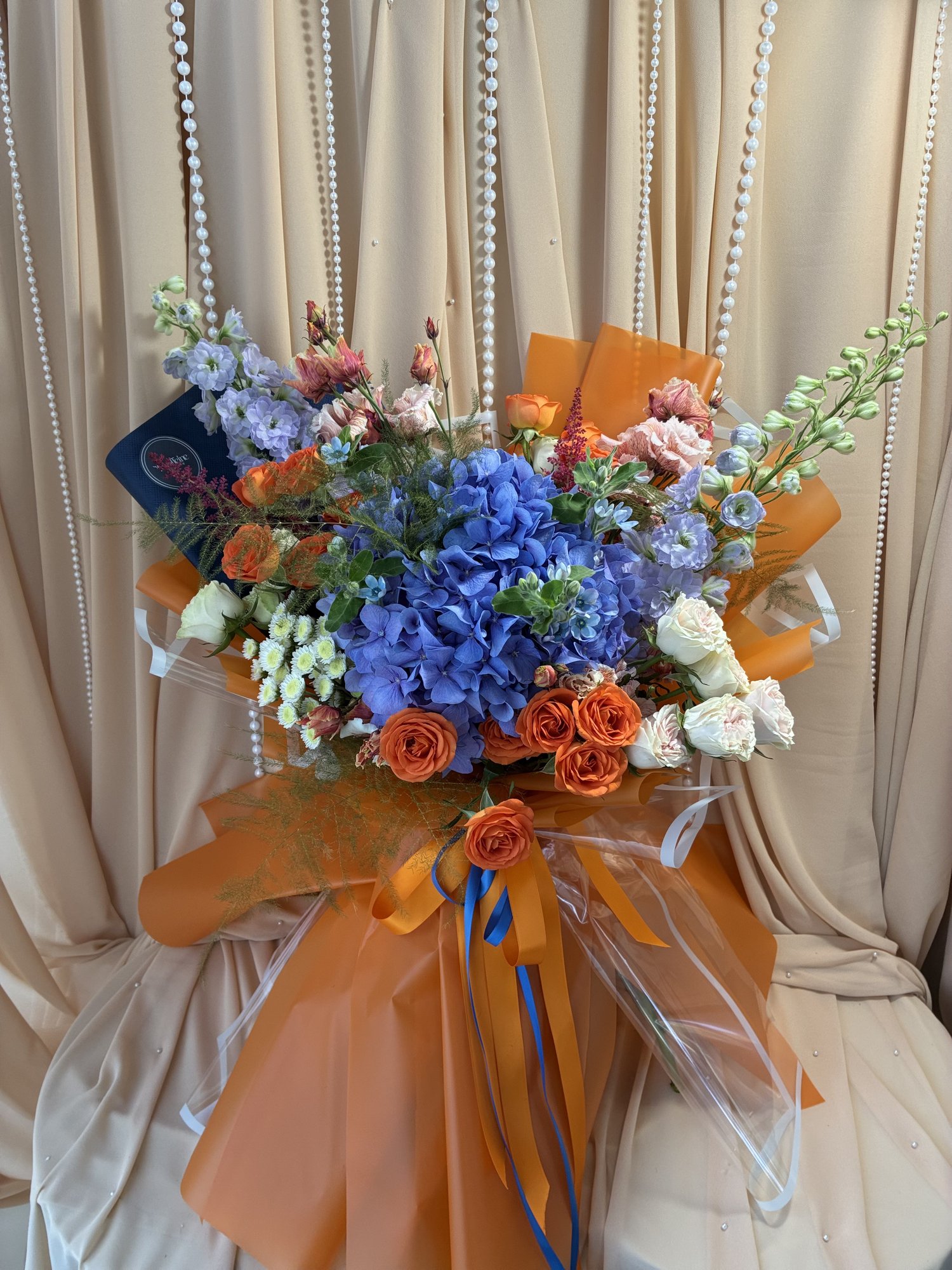 Blue Ember – Buchet cu hortensie albastră, trandafiri portocalii și Delphinium